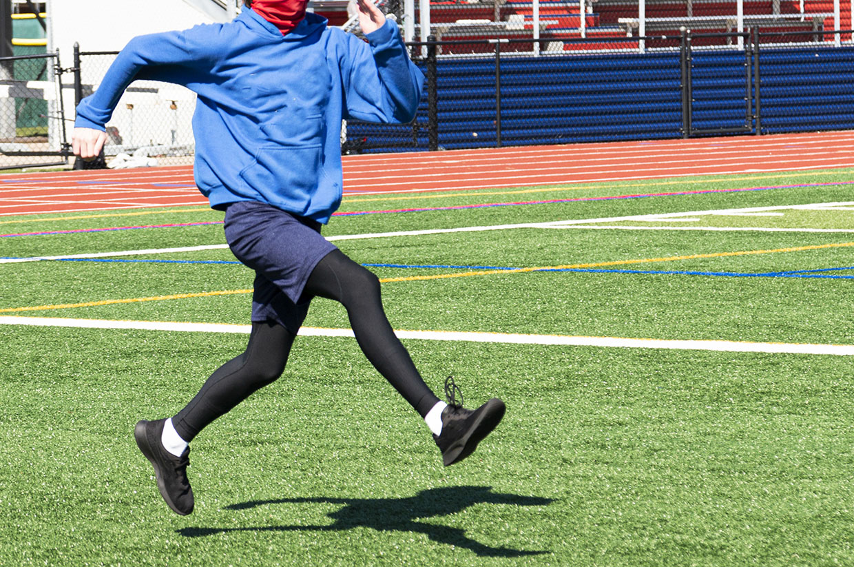 High School Runner Practicing Straight Leg Bounding Sports Drill High School Runner Practicing Straight Leg Bounding Sports Drill
